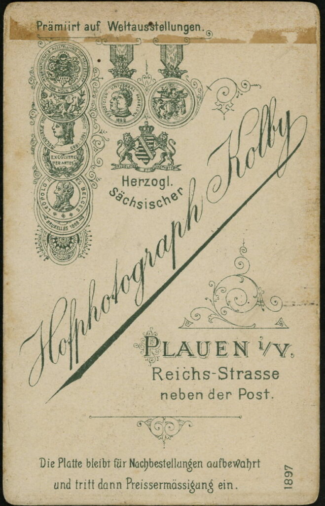 Reverse of a monochrome photographic portrait from between 1865 and the 1920s taken in Atelier Kolby, Reichs-Straße, Plauen i. V. and dated 1897