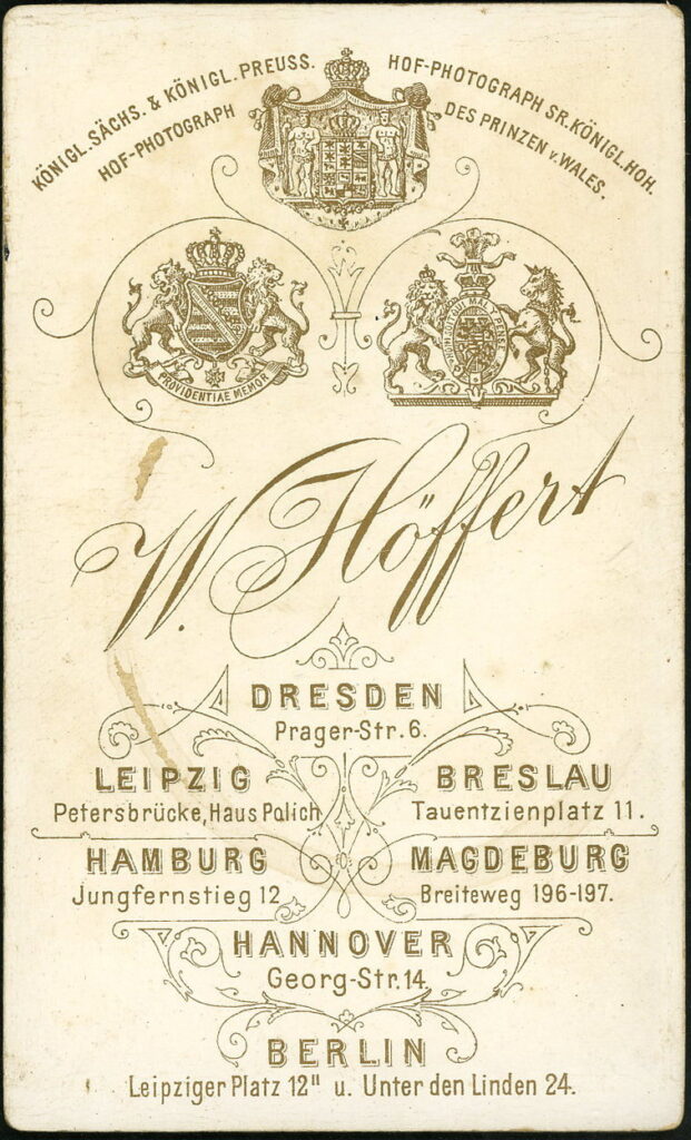 Reverse of a monochrome photographic portrait from between 1865 and the 1920s taken by W. Höffert, Prager-Straße 6, Dresden, Petersbrücke, Leipzig, Tauentzienplatz 11, Breslau, Jungfernstieg 12, Hannover, Breiteweg 196-197, Magdeburg, Georg-straße 14, Hannover, Leipziger Platz 12, Berlin, Unter den Linden 24, Berlin