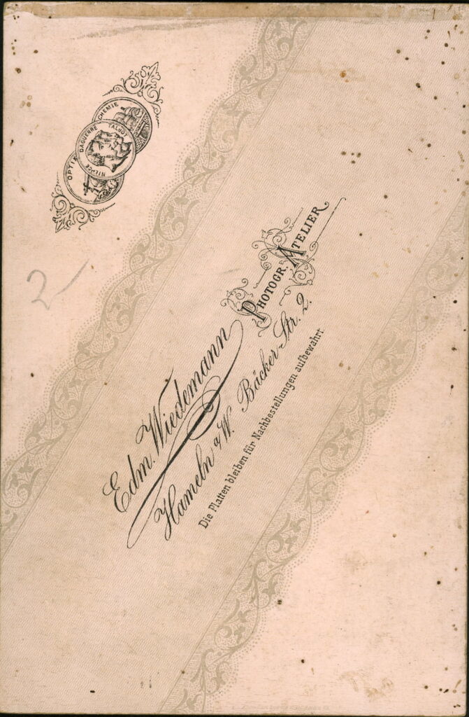 Reverse of a monochrome photographic portrait from between 1865 and the 1920s taken by Edm. Wiedemann, Bäcker-Straße 2, Hameln a. W.