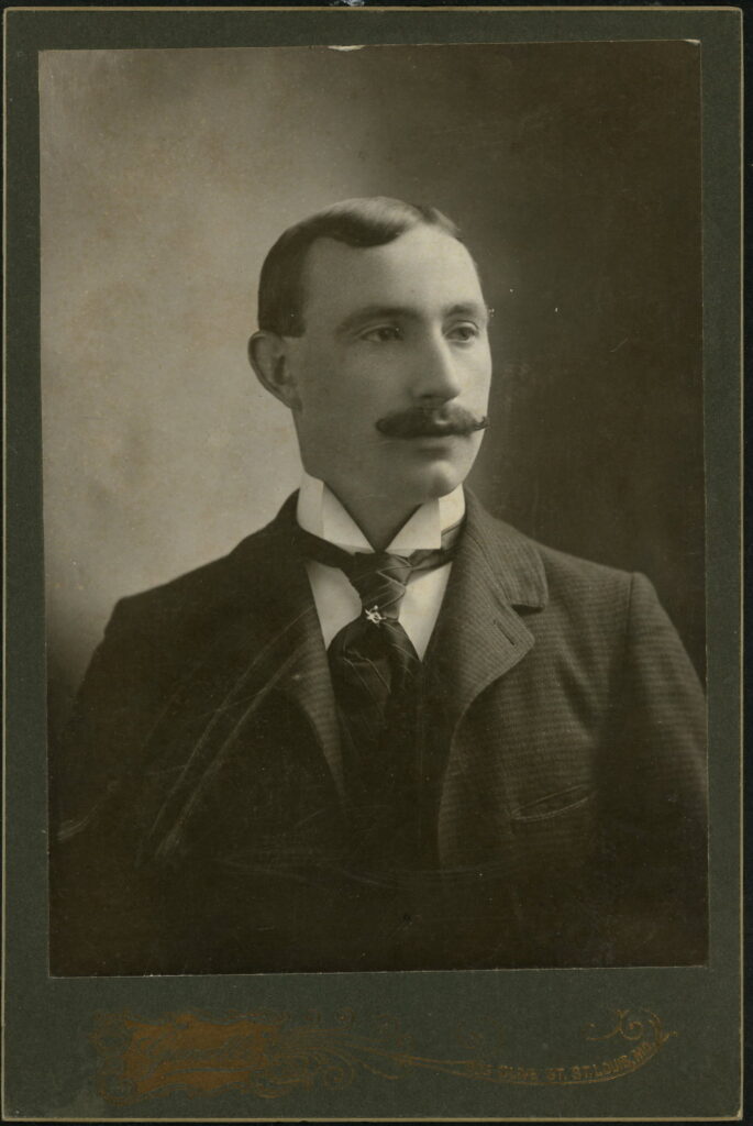 A monochrome photographic portrait from between 1865 and the 1920s taken by Genelli, 923 Olive Street, St Louis, MO